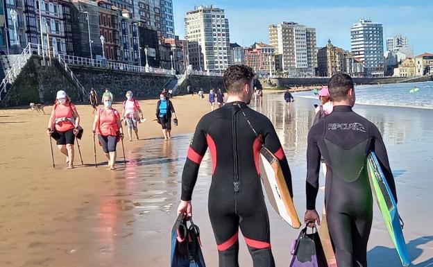 Dos surfistas pasean este miércoles en la playa de San Lorenzo 