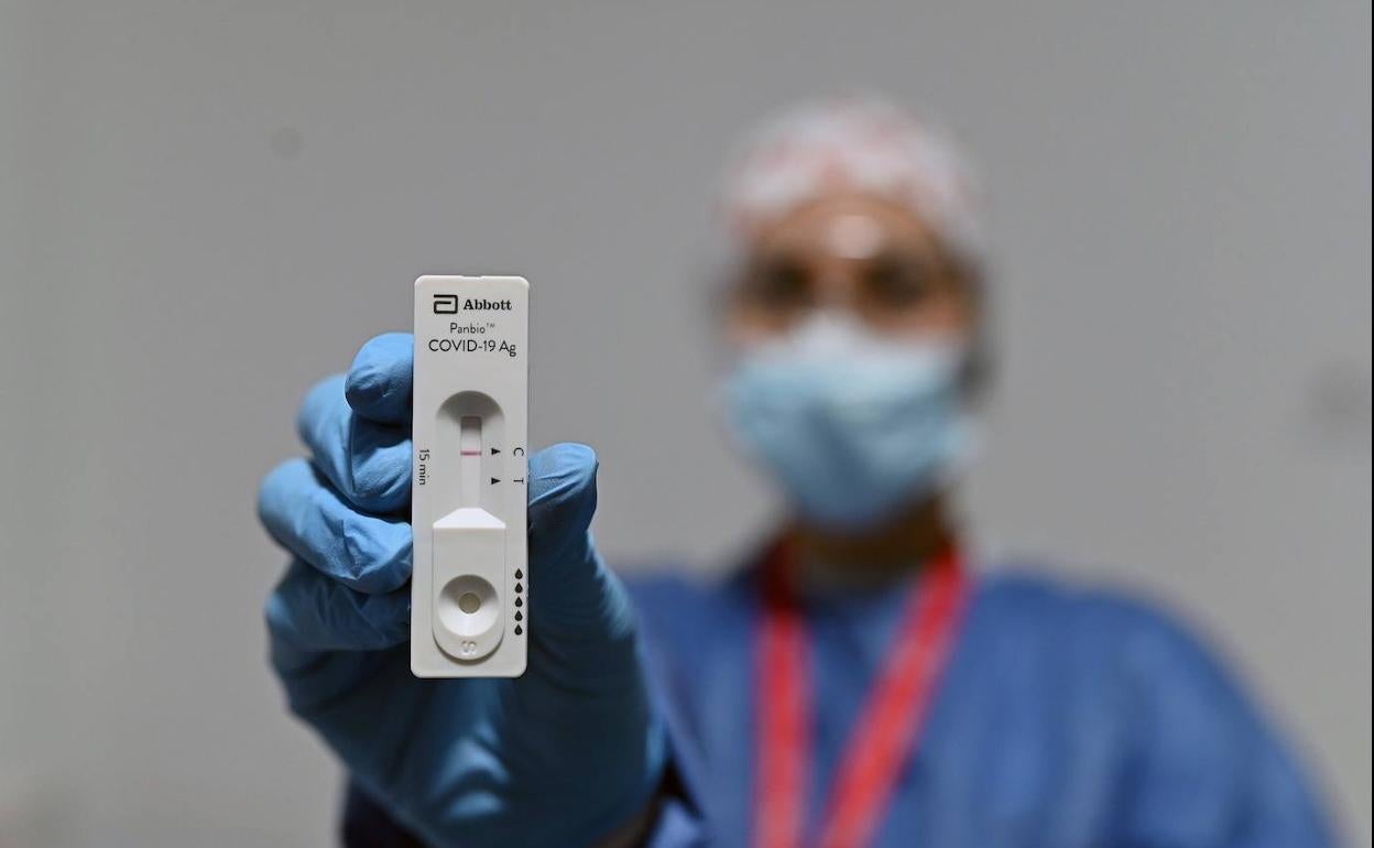 Una personas muestra una prueba PCR. 