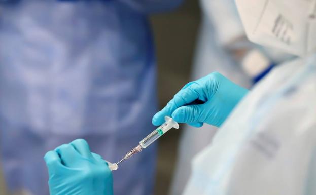 Una enfermera se dispone a vacunar a un paciente. 