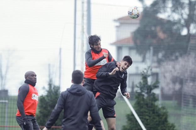 Marc Valiente, durante el entrenamiento de ayer, disputa un balón aéreo con Pablo Pérez. 