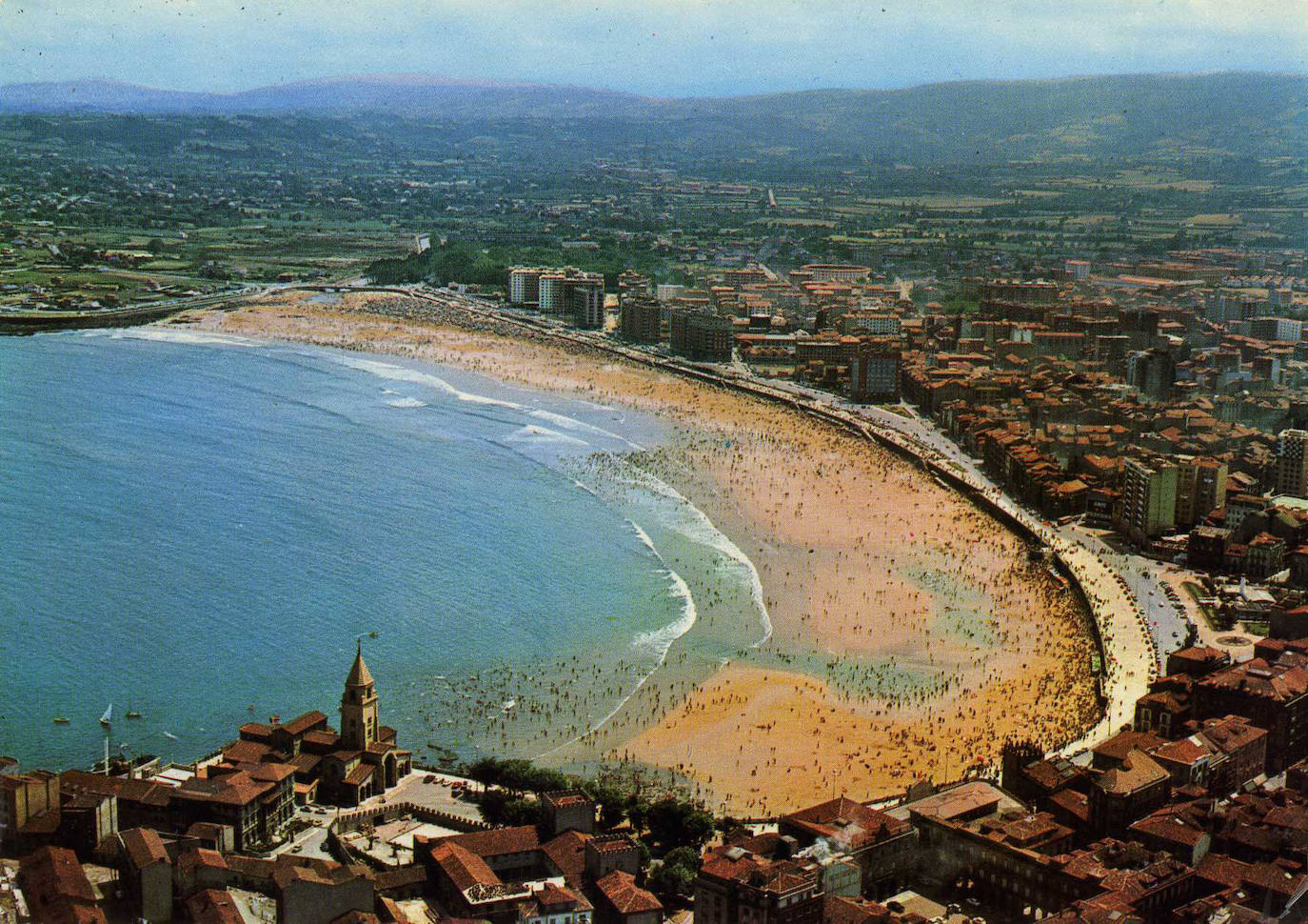 Un paseo por la historia gráfica de la playa de San Lorenzo que arranca con una reproducción de 1900 permite comprobar si el paso de los años han cambiado la orografía y el aspecto del arenal después de que el Ministerio de Transición Ecológica y el Reto Demográfico augurara en un informe que Gijón sufrirá daños anuales de 10 millones por la subida del mar debido al cambio climático