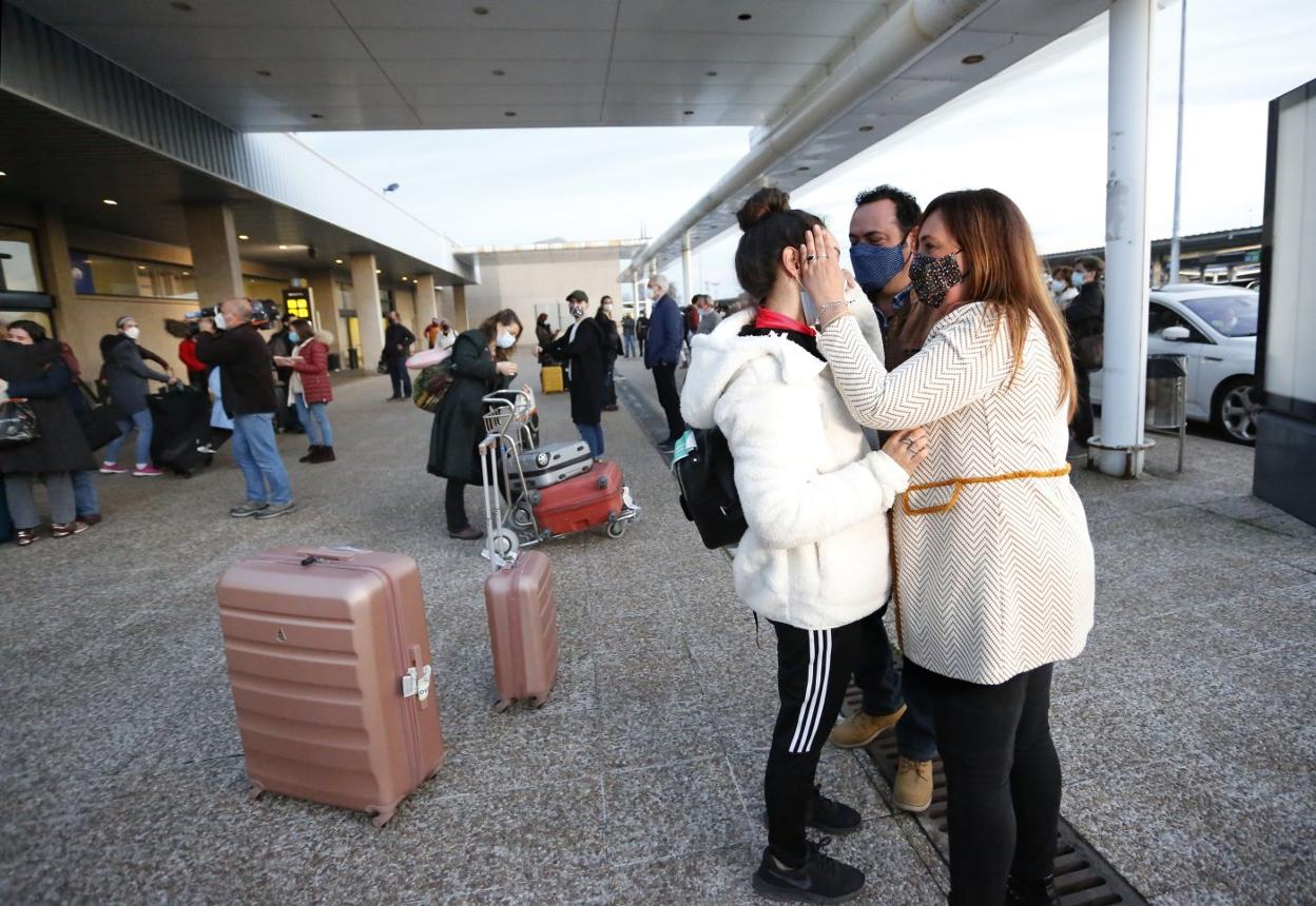 Unos padres reciben a su hija a la llegada de un vuelo de Londres en el Aeropuerto de Asturias. 