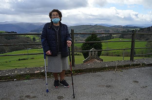 Manolita Martínez en pleno paseo por Santullano, con la capilla de la Soledad al fondo. 