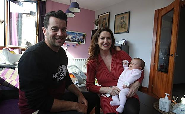 Juan Riestra y María Menéndez con su hija Lara en el salón de su casa. 
