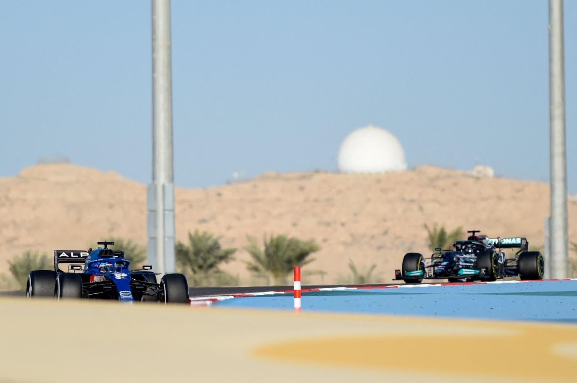 El Alpine A521, con Alonso a los mandos, adelanta al Mercedes W12 de Hamilton, en el circuito de Sakhir. 