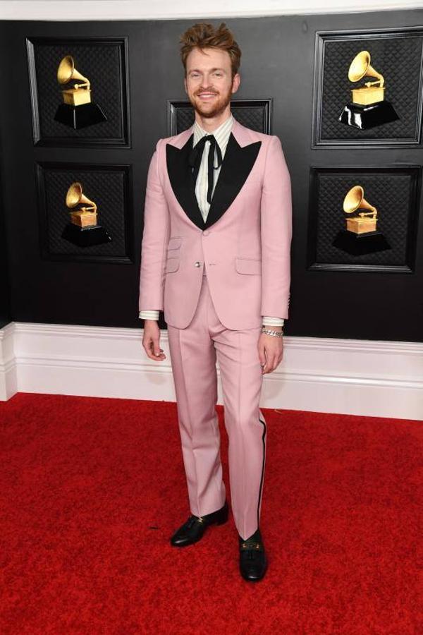 Finneas Baird eligió este traje rosa con solapas en color negro y camisa de rayas con lazada.