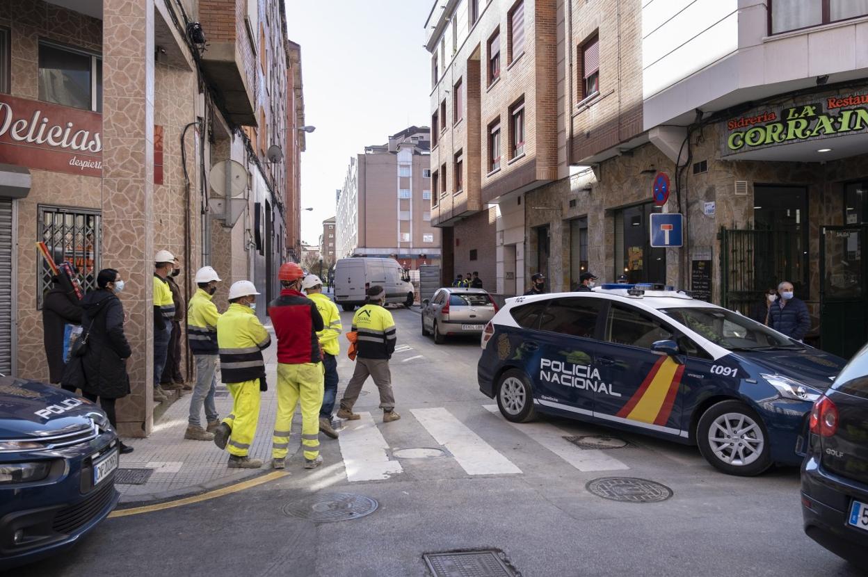 Policía Nacional y operarios, tras hallar el artefacto, a cierta distancia del solar. 