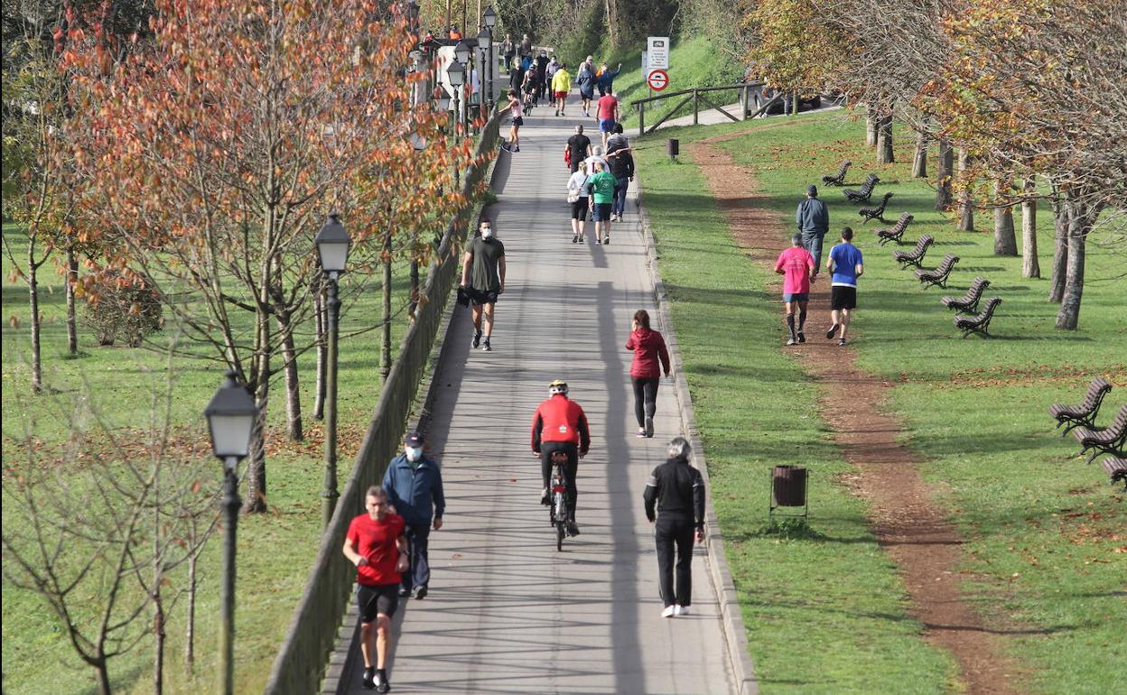 Gente caminado y haciendo deporte por el Parque de Invierno de Oviedo.