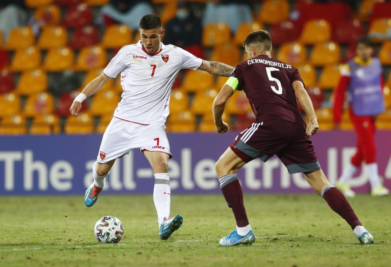 El sportinguista Djuka remata ante la oposición del capitán letónCernomordijs, durante su debut internacional con Montenegro en Riga. 