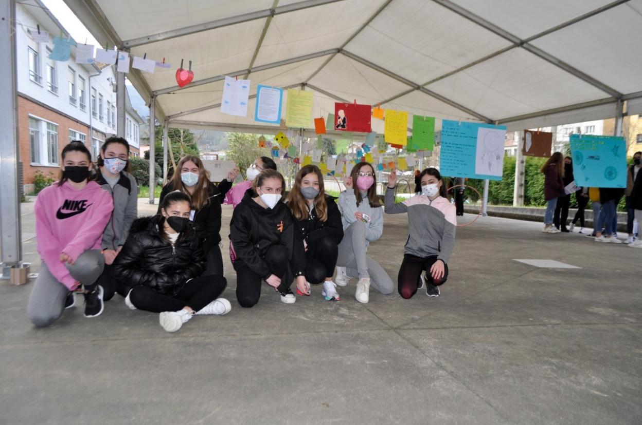 Alumnas junto a los poemas colocados en la carpa del centro. 