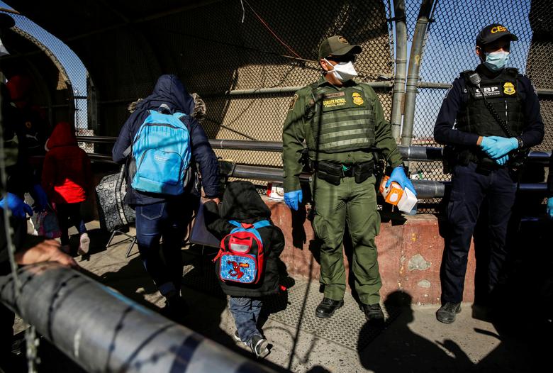 Migrantes, bajo el programa de Protocolos de Protección al Migrante (MPP), caminan luego de cruzar de México a los Estados Unidos para continuar su solicitud de asilo en los Estados Unidos, en esta foto tomada desde Ciudad Juárez, México.