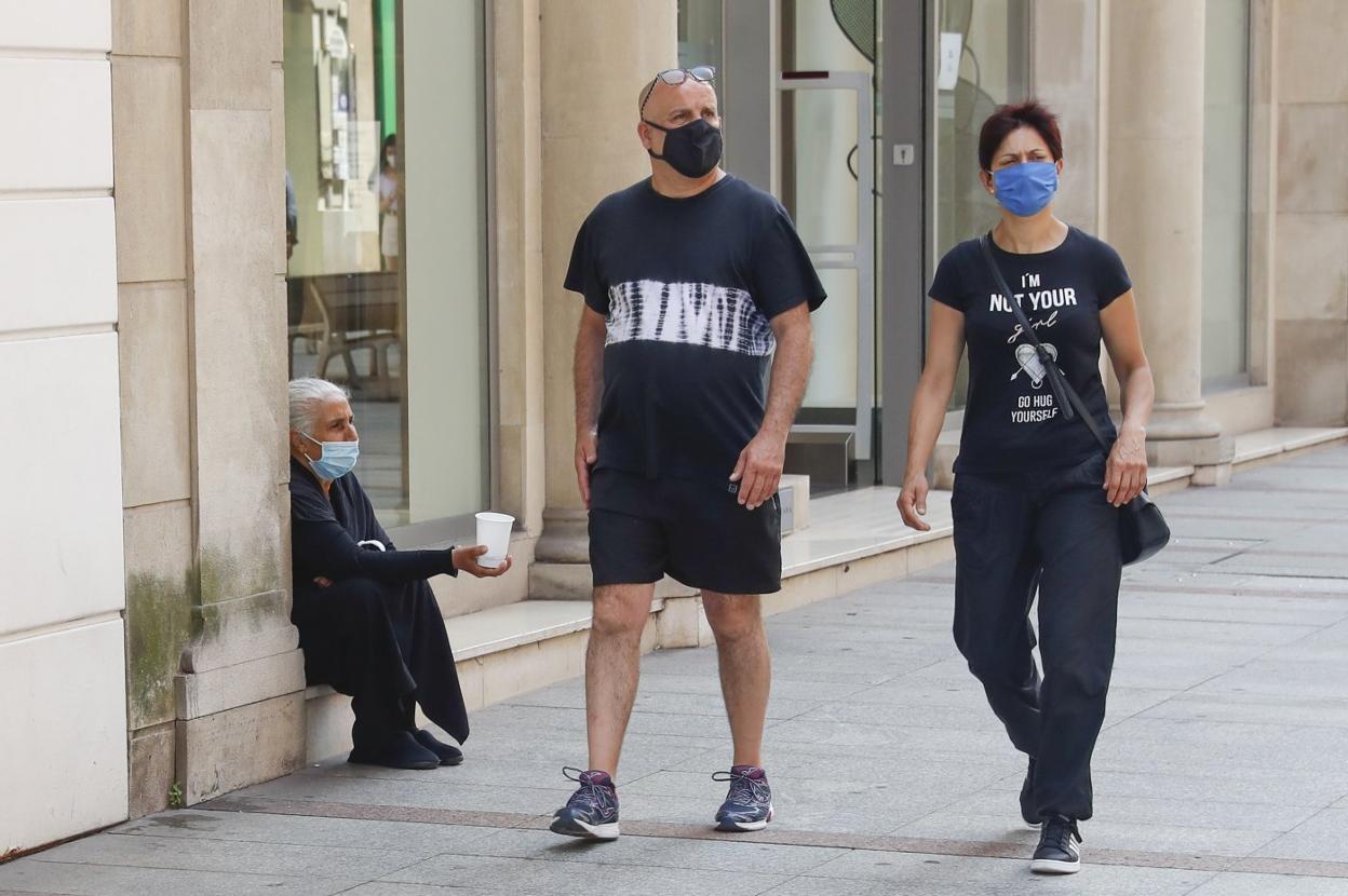 Una mujer pide limosna en una céntrica calle de Gijón. 