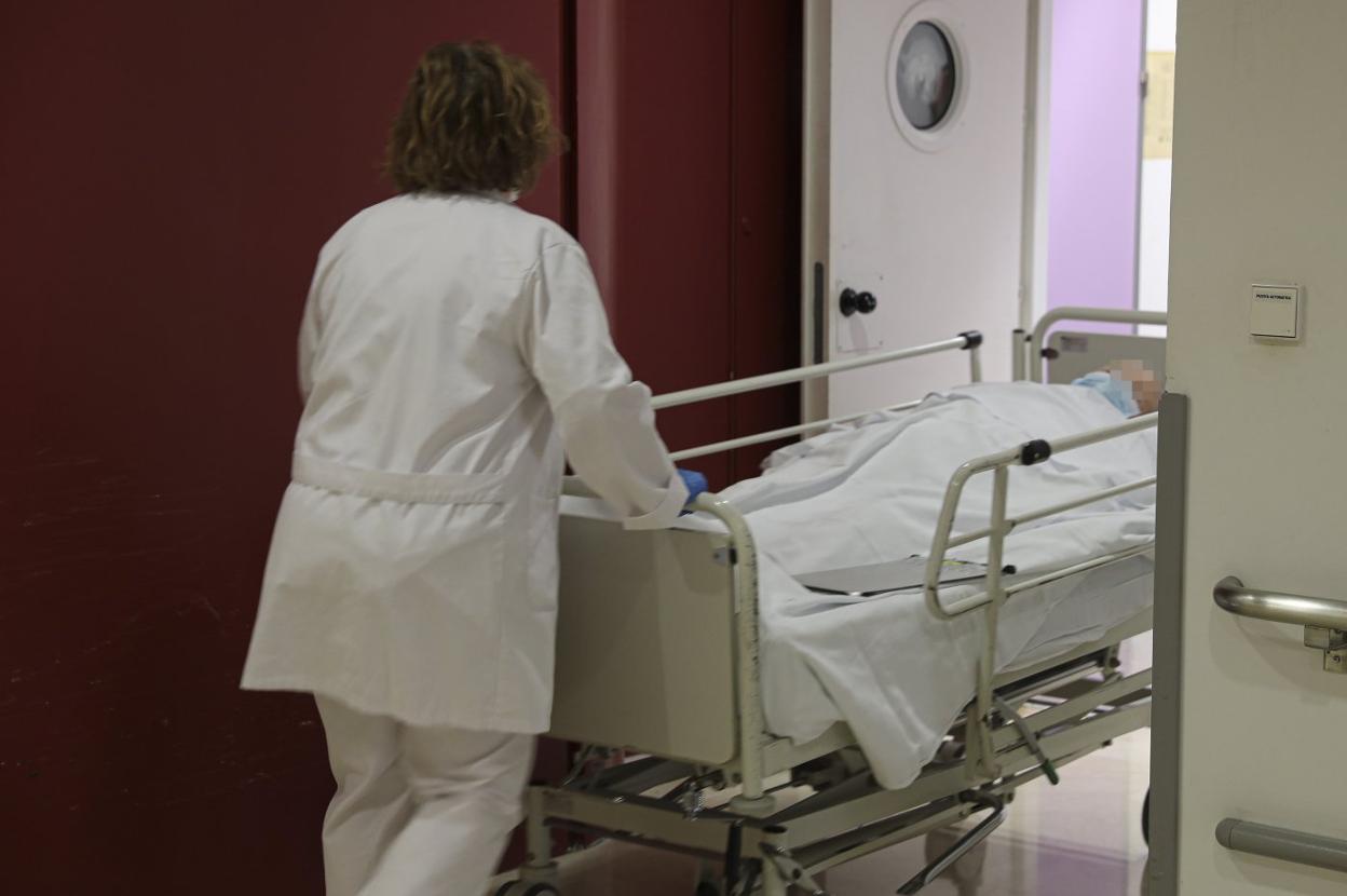 Una trabajadora del Hospital de Cabueñes traslada a una paciente ingresada. 