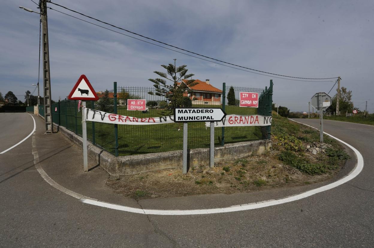 Cruce que da acceso a la finca comprada por ITVASA para construir la ITV, con los arcenes desbrozados, las líneas de la carretera recién pintadas y carteles de protesta. 