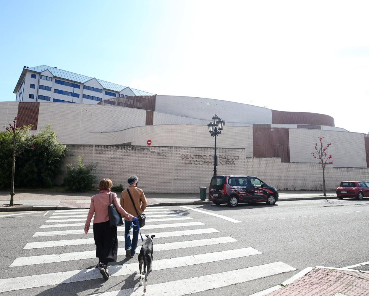 Una pareja cruza frente al centro de salud de La Corredoria, zona donde se realizó el estudio. 