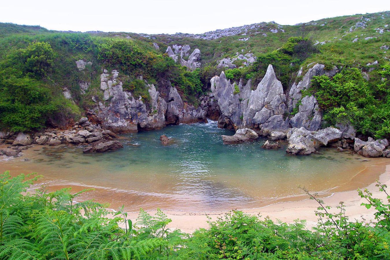 Playa de Gulpiyuri: Esta pequeña playa situada al oeste de la playa de San Antolín de Bedón y rodeada de verdes praderías, destaca por encontrarse separada del mar por unos acantilados. En concreto la zona arenosa conecta con el mar a través de una cueva que en pleamares se llena de agua formando una piscina natural de agua cristalina y que en las bajamares deja a la vista su zona arenosa. Un espacio de gran singularidad geológica y paisajística y también está declarado Monumento Natural.