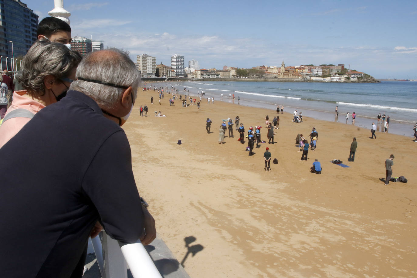 Amplio dispositivo policial en la mañana de este sábado en la playa de San Lorenzo para disolver a un grupo de personas que permanecía en el arenal sin mascarilla. Fueron obligados por los agentes a ponerse las protecciones.