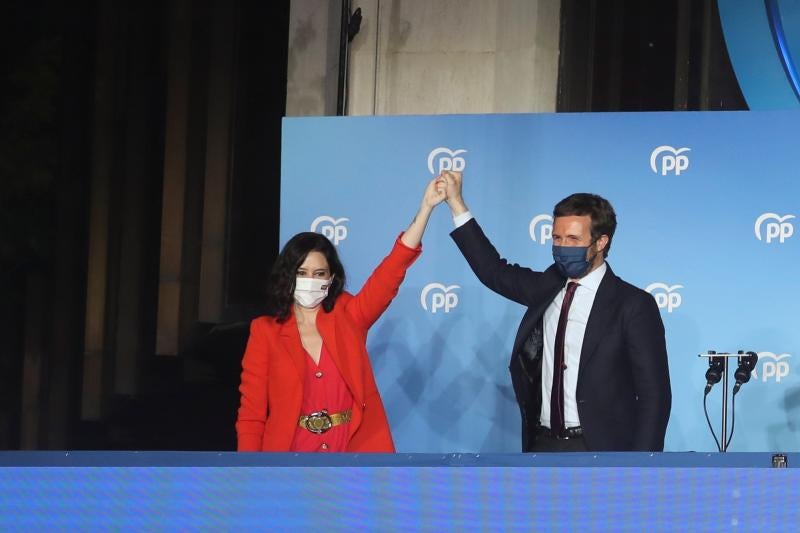 Isabel Díaz Ayuso y Pablo Casado levantan los puños y agradecen la presencia a los asistentes.