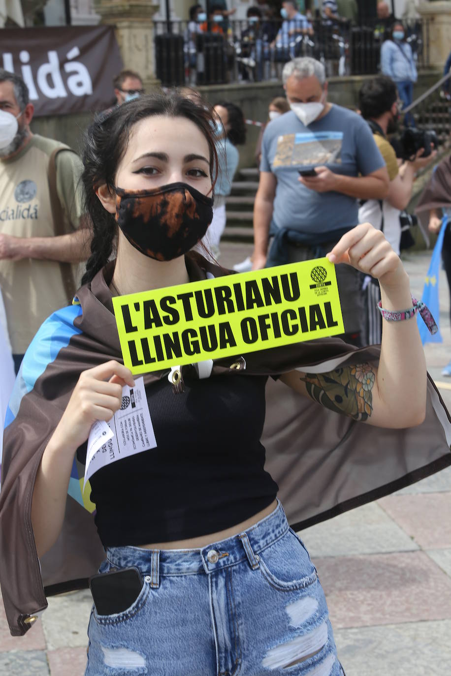 La tradicional manifestación de la Xunta pola Defensa de la Llingua en el Día de les Lletres se sustituyó este sábado por un mosaico de banderas en la plaza de la Catedral con la palabra 'oficialidá'.