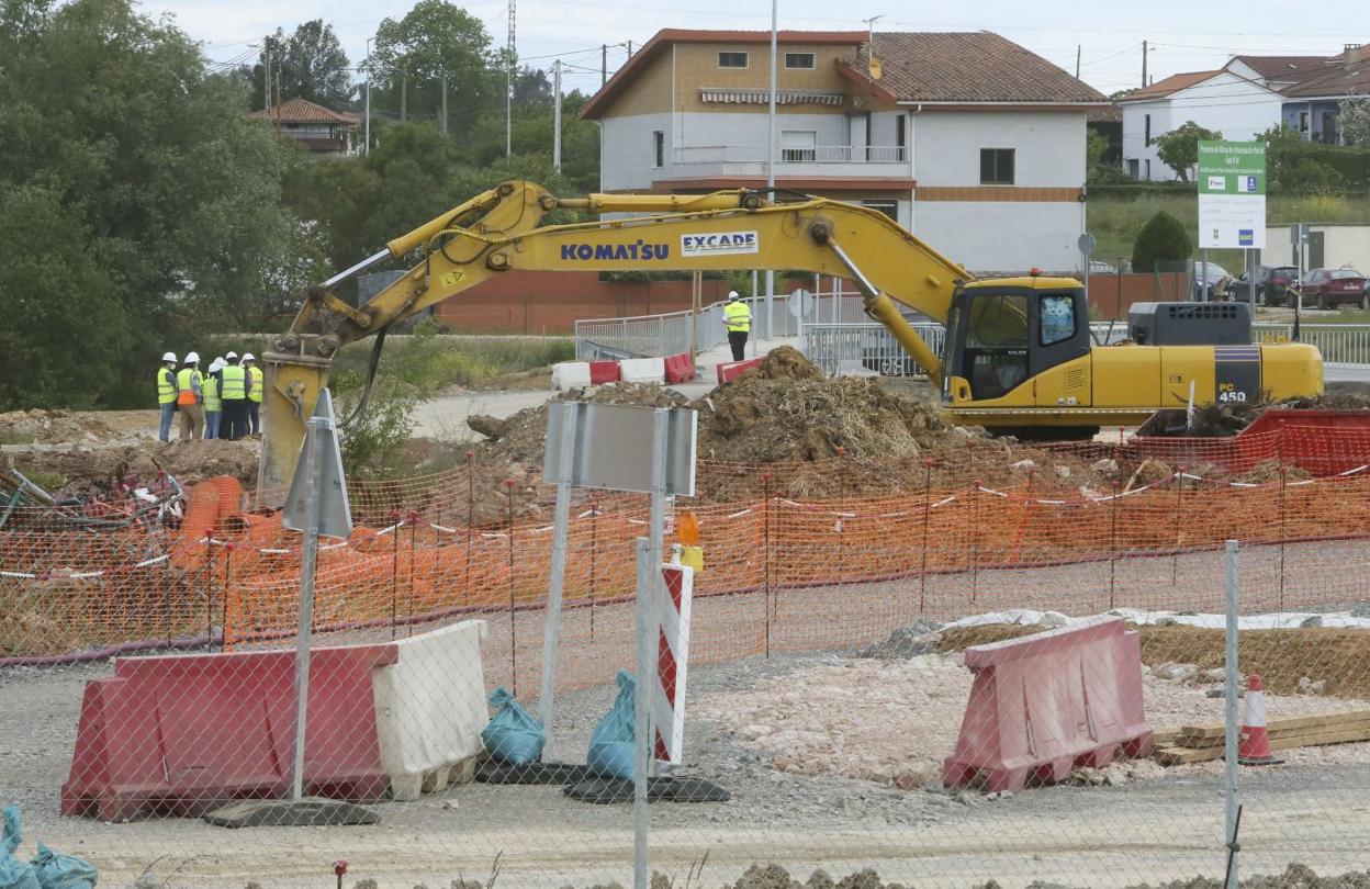 Varios trabajadores reunidos cerca de una de las palas que actualmente trabajan en la parcela del Polígono de Bobes. 