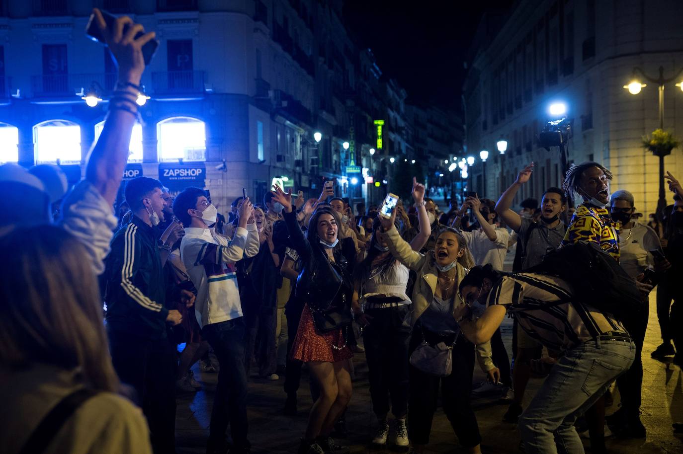 En Barcelona y Madrid muchos jóvenes no se han resistido a celebrar el fin de seis meses de estado de alarma y han salido a las calles como si se tratara de una típica Nochevieja. Las aglomeraciones y la falta de distancia han sido la tónica de estas 'fiestas'.