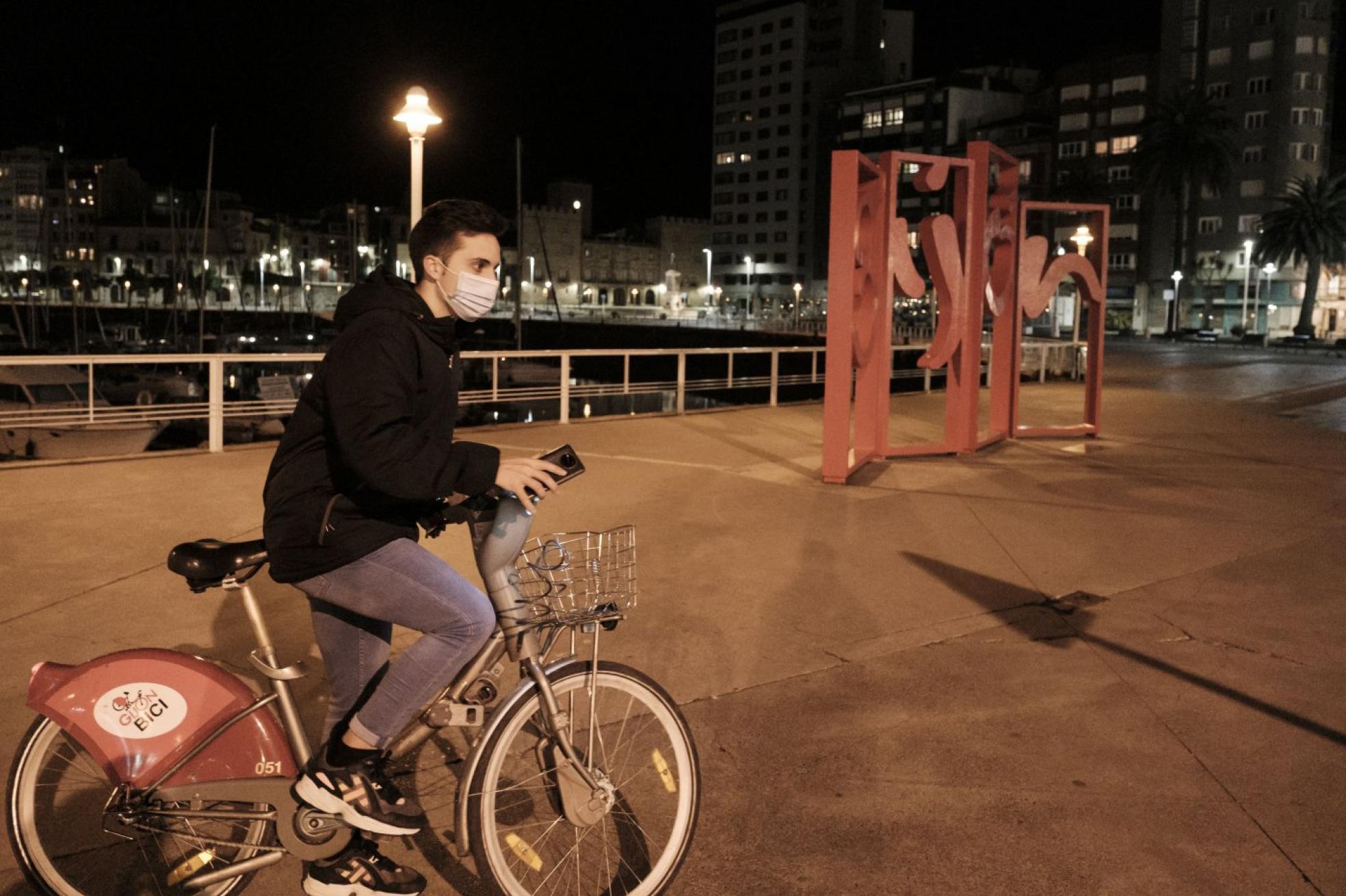 p Sobre ruedas. Un joven pasa en bicicleta junto a las Letronas minutos después del final del estado de alarma. 
