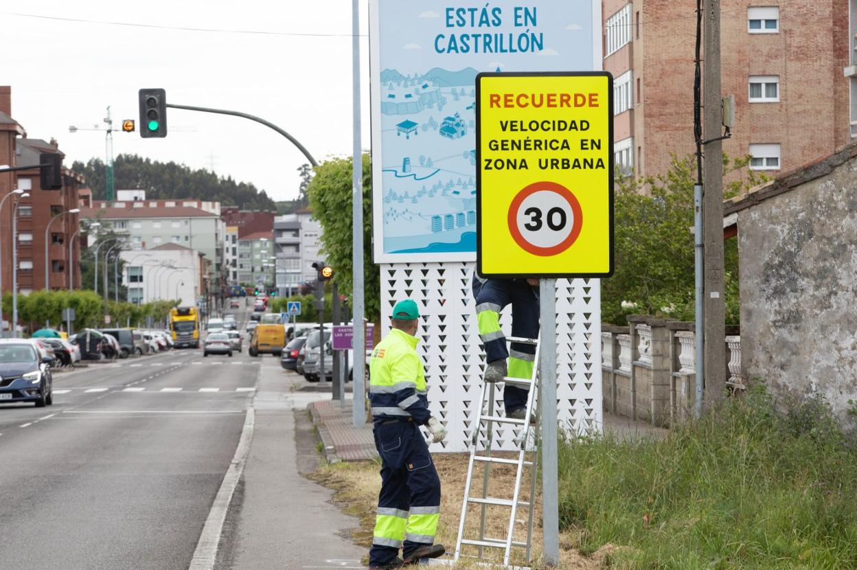 Operarios cambian la señalización en la avenida de Galicia de Piedras Blancas. 
