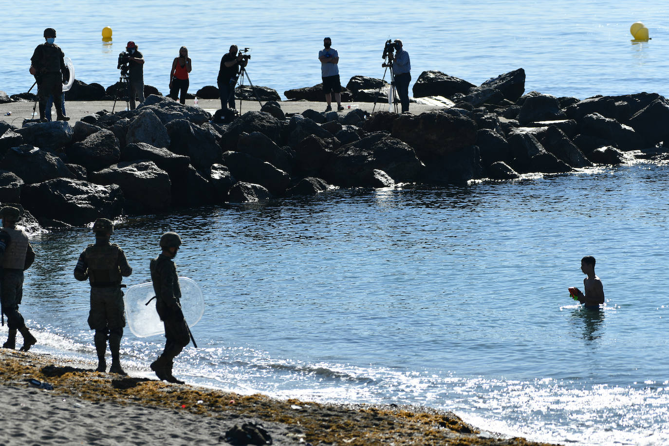  Por segundo día consecutivo, Ceuta ha vivido una crisis migratoria que está dejando datos e imágenes escalofriantes. En la costa ceutí se ha visto la llegada de miles de personas exhaustas, entre ellos jóvenes y niños, tras lanzarse al mar desde Marruecos para tratar de llegar a territorio español, ante la impasibilidad de los militares marroquíes. Algunas de estas personas han tenido que utilizar botellas de plástico a modo de flotador y otras han tenido que ser atendidas en la playa por las Fuerzas y Cuerpos de Seguridad y por voluntarios. 