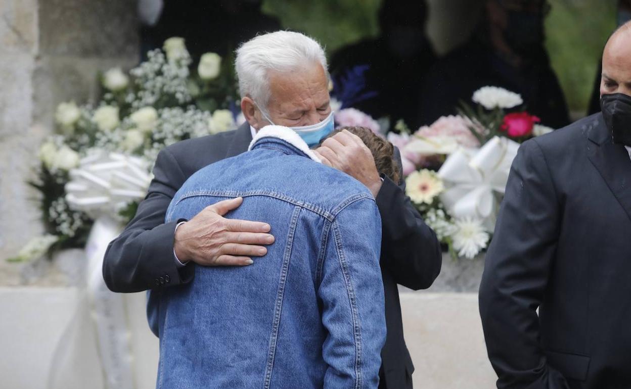 El padre de Teresa consuela a su nieto en el funeral.