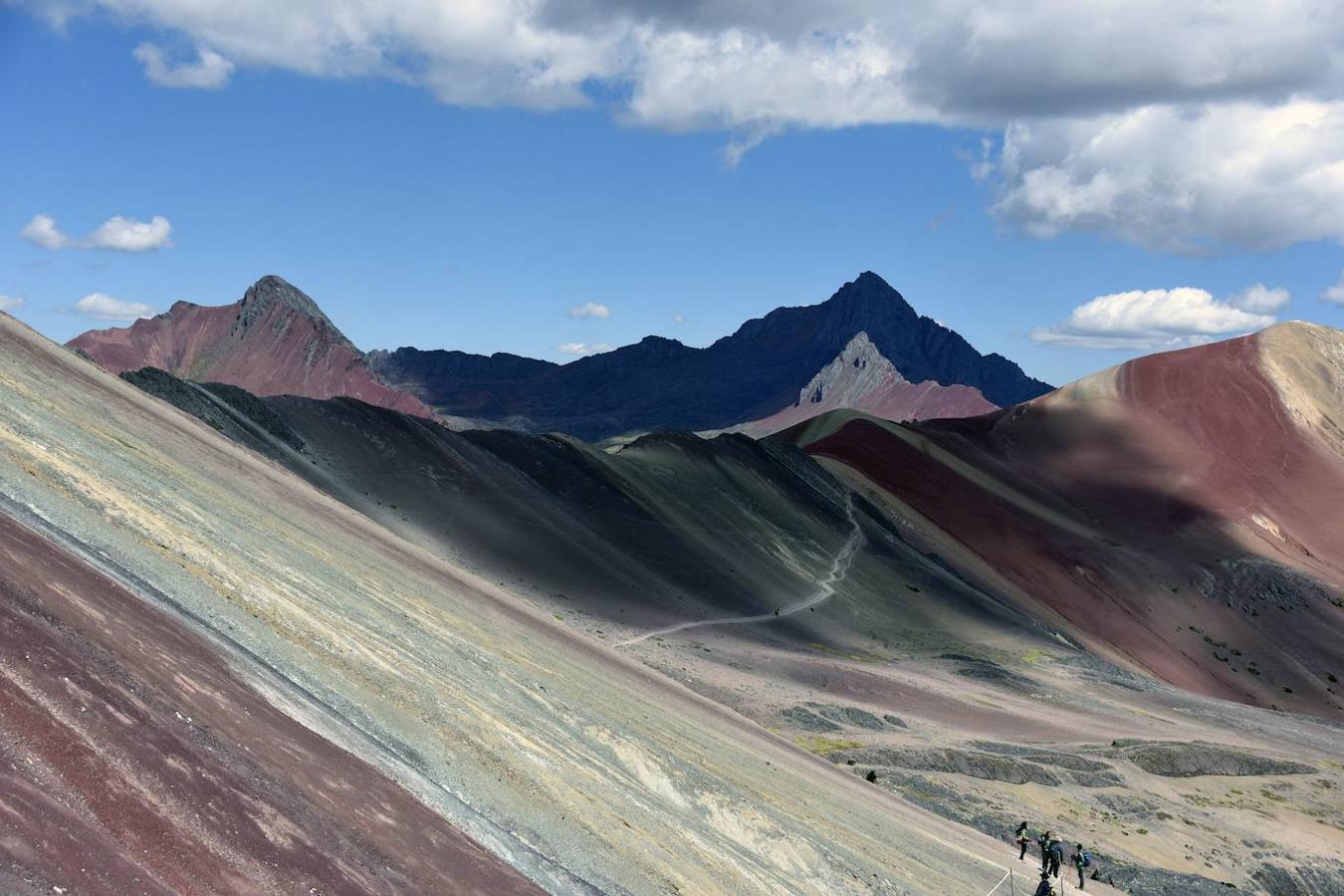 Vinicunca (Perú): Este auténtico arcoiris en la montaña, lo encontrarás a unos 100 kilómetros al suroeste de Cusco (Perú) y a 5.200 metros de altitud. Una montaña también conocida como la montaña de los Siete Colores en la que, tanto sus laderas como cumbres, las encontrarás repletas de intensos tonos lavanda, turquesa, fucsia o incluso dorado. Unos colores relacionados con la historia geológica de este lugar y los sedimentos marinos que fueron transportados en el terciario y cuaternario por el agua que cubría estas montañas, hasta que con el paso del tiempo se llegasen a formar capas con diferentes tipos de grano que fueron adquiriendo diferentes colores por la oxidación de sus minerales.