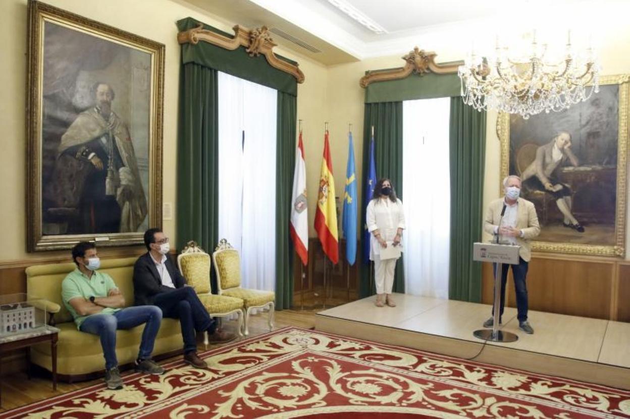 Aurelio Martín, durante la presentación del protocolo, con la portavoz del gobierno local, Marina Pineda, de pie, y Cosme García y Jesús Fernández sentados en el salón de recepciones del Ayuntamiento. 