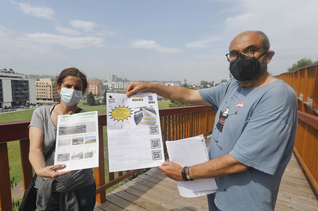 Miguel Bernardo y Flo García, presidente y colaboradora de la asociación de vecinos, con los carteles del festejo de Nuevo Roces. 