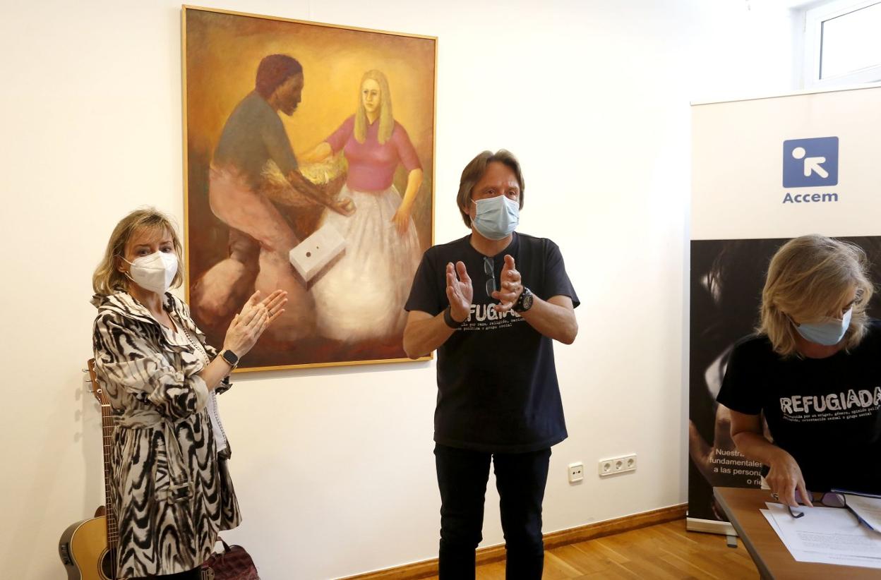 Julia Magdalena y Javier Mahía descubren el cuadro 'Razas', donado a Accem por el pintor Julio Magdalena. 