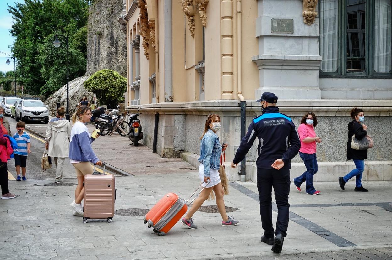 Un agente de la Policía Local insta a unas turistas a ponerse correctamente la mascarilla. 
