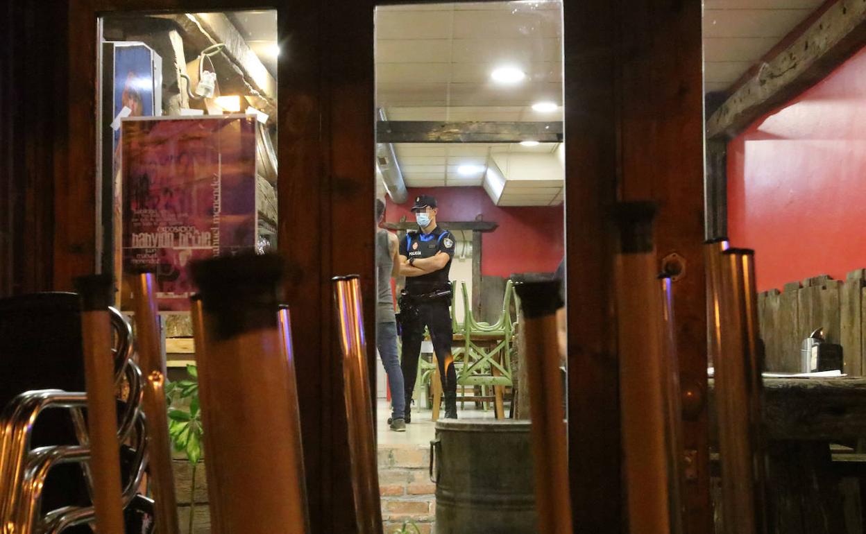 Un policía en un bar de copas en Oviedo durante el periodo de cierre del ocio nocturno.