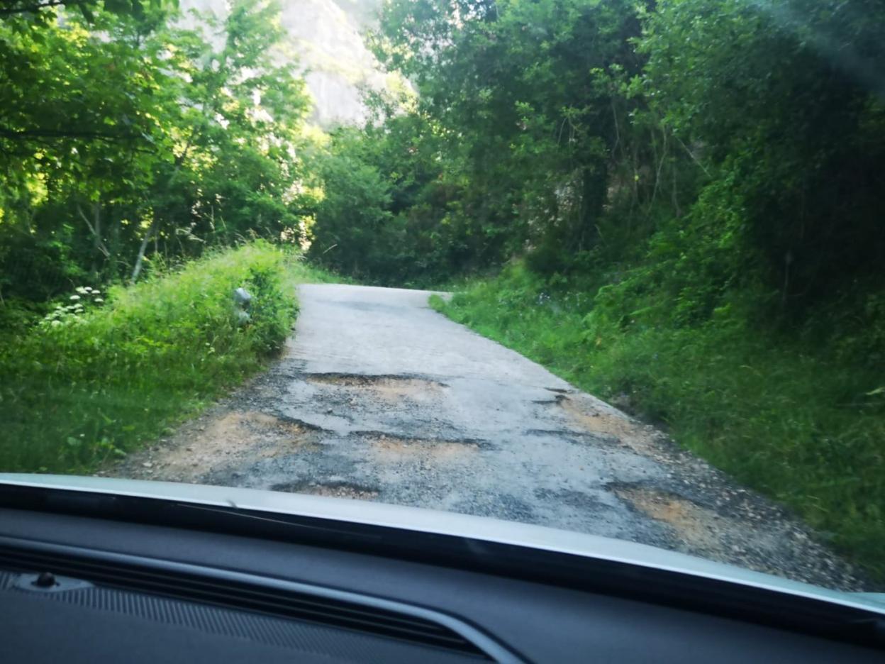 Algunos de los baches que presenta la carretera de acceso a Perlunes. 