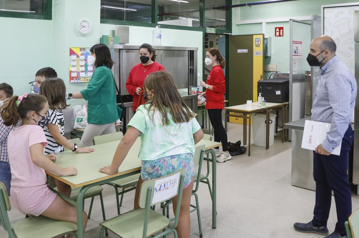 Santos Tejón (derecha) observa a las monitoras y los niños, en el colegio Río Piles. 