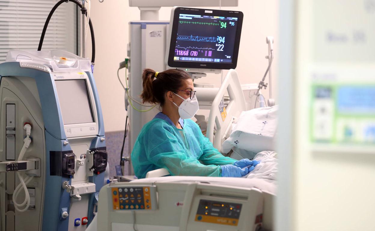 Una profesional sanitaria atiende en la UCI del HUCA.