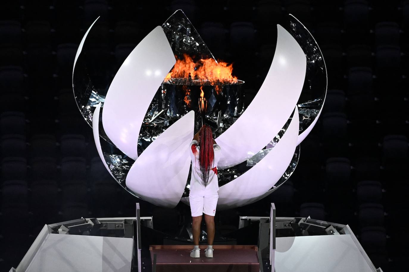 Los Juegos que más se han demorado han dado finalmente arranque tras más de un año. La ceremonia de inauguración, en la que las delegaciones desfilan cada cuatro años ante unas gradas entusiastas, fue en esta ocasión un acto desangelado, debido a la ausencia de público en las competiciones. Sin embargo, algunos rituales se repitieron, como el del encendido del pebetero, uno de los secretos mejor guardados en cada cita y que en esta ocasión consistió en un recipiente esférico inspirado en el Sol. La delegación española, de la que se muestran imágenes, estuvo abanderada por el palista Saúl Craviotto y la nadadora Mireia Belmonte.