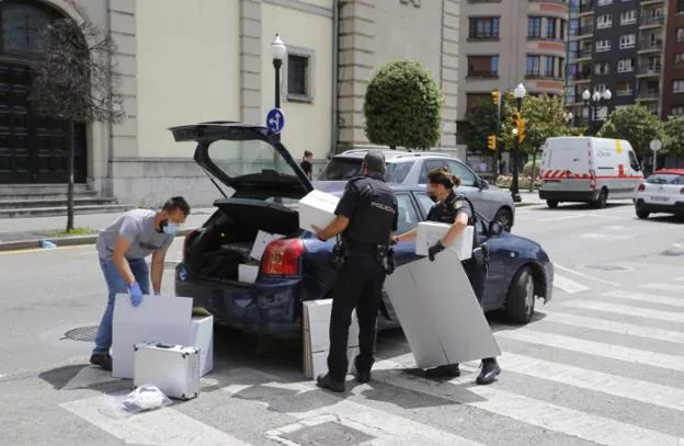 Agentes de la Policía Científica, delante de la iglesia de San José, introducen en una coche cajas con presunto material probatorio del delito sexual cometido. 