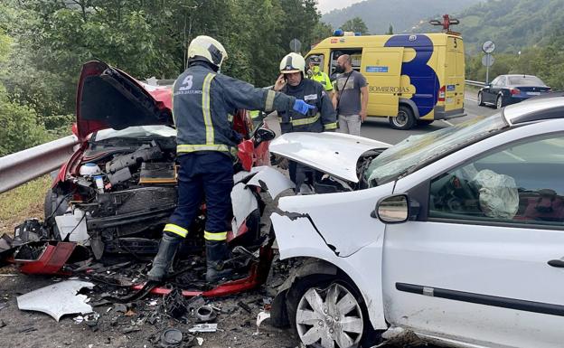 Los bomberos observan el estado en el que quedaron los vehículos.