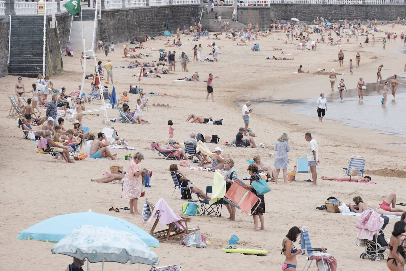 Está siendo un verano atípico en la costa asturiana, pero el mal tiempo no ha impedido que los bañistas se lancen a la playa de San Lorenzo con ganas de disfrutar del día. Algunos pasean, otros leen con la ropa puesta y los más valientes se atreven a darse un chapuzón. Cualquier plan es preferible a quedarse en casa.