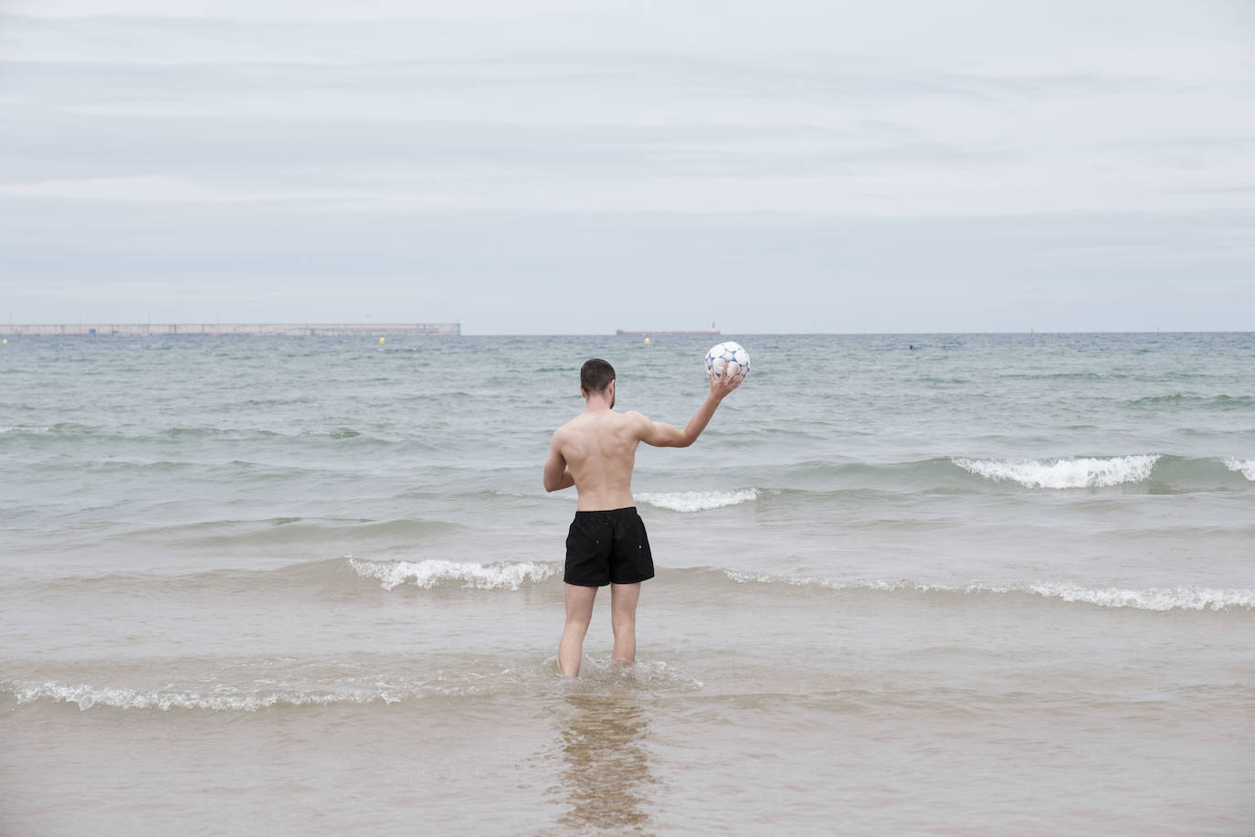 Está siendo un verano atípico en la costa asturiana, pero el mal tiempo no ha impedido que los bañistas se lancen a la playa de San Lorenzo con ganas de disfrutar del día. Algunos pasean, otros leen con la ropa puesta y los más valientes se atreven a darse un chapuzón. Cualquier plan es preferible a quedarse en casa.