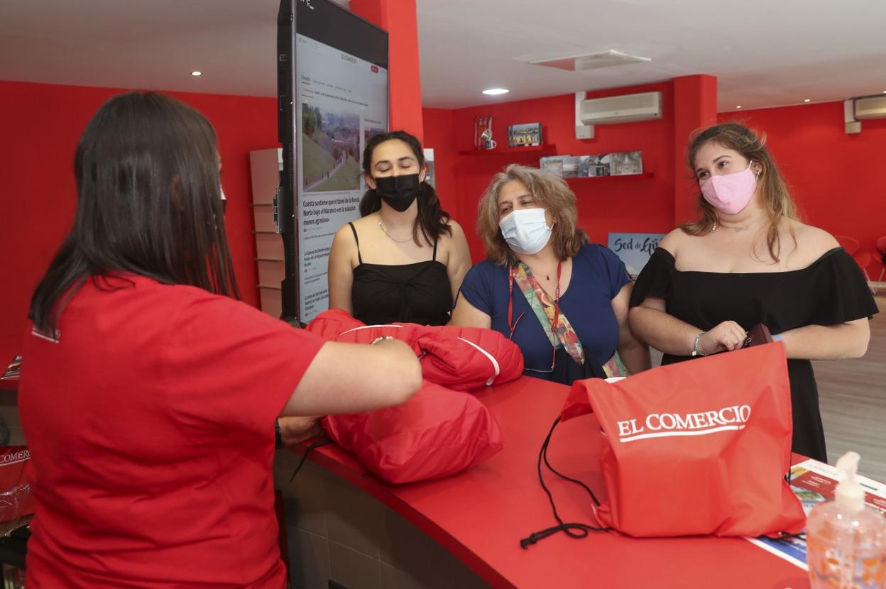 Visitantes en el estand de EL COMERCIO con la nueva bolsa especial, a la derecha, y la chaqueta sportinguista, a la izquierda.