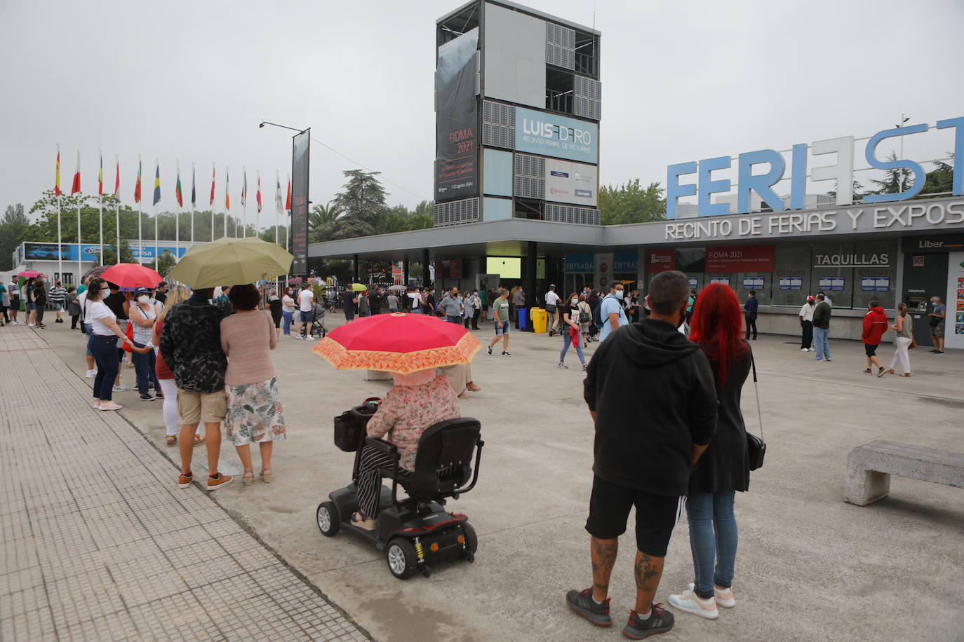 14 de agosto. El centro de Asturias amanece con lluvias débiles, pero eso no impide que decenas de personas, paraguas en mano, hagan cola a las puertas del ferial Luis Adaro de Gijón para disfrutar de un día en la Feria de Muestras. 