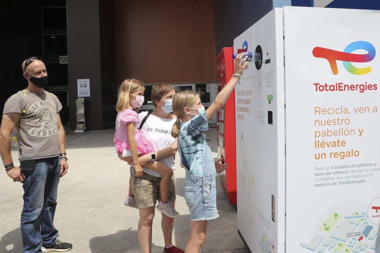 Jara Rodríguez, junto a su hermana Vera, recicla una botella en presencia de sus padres, Aida Prado y Roberto Rodríguez.