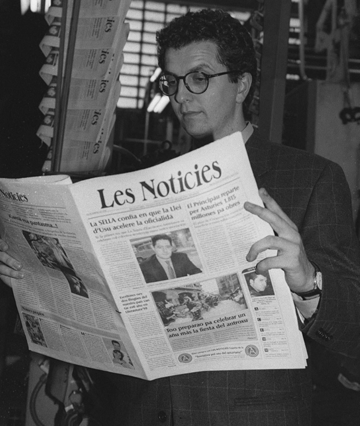 Inaciu Iglesias, en 1998, con un exemplar de Les Noticies, y la primer portada del semanariu. 
