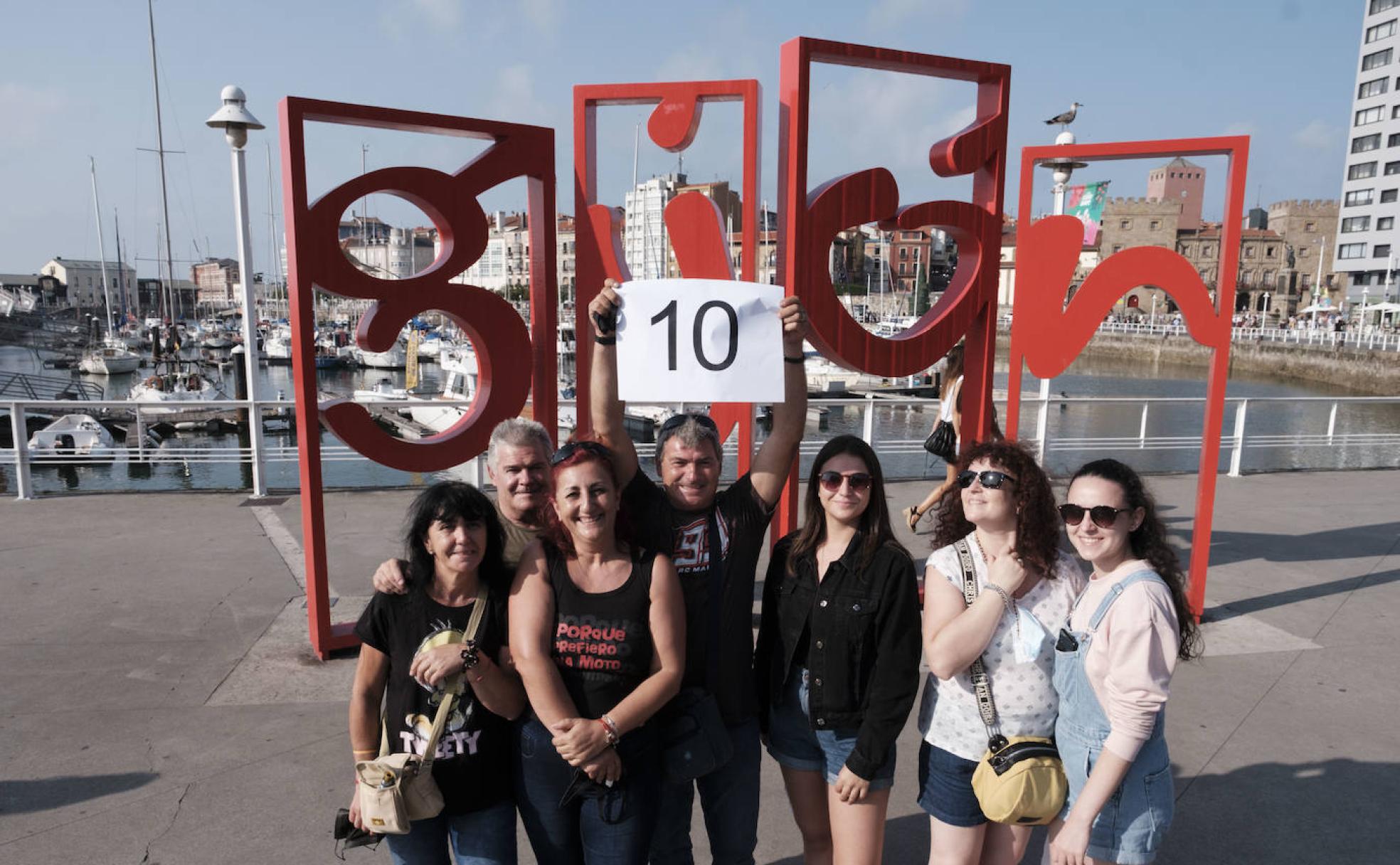 Un grupo de turistas, junto a las letronas de Gijón, puntúan el verano asturiano con la nota máxima. 
