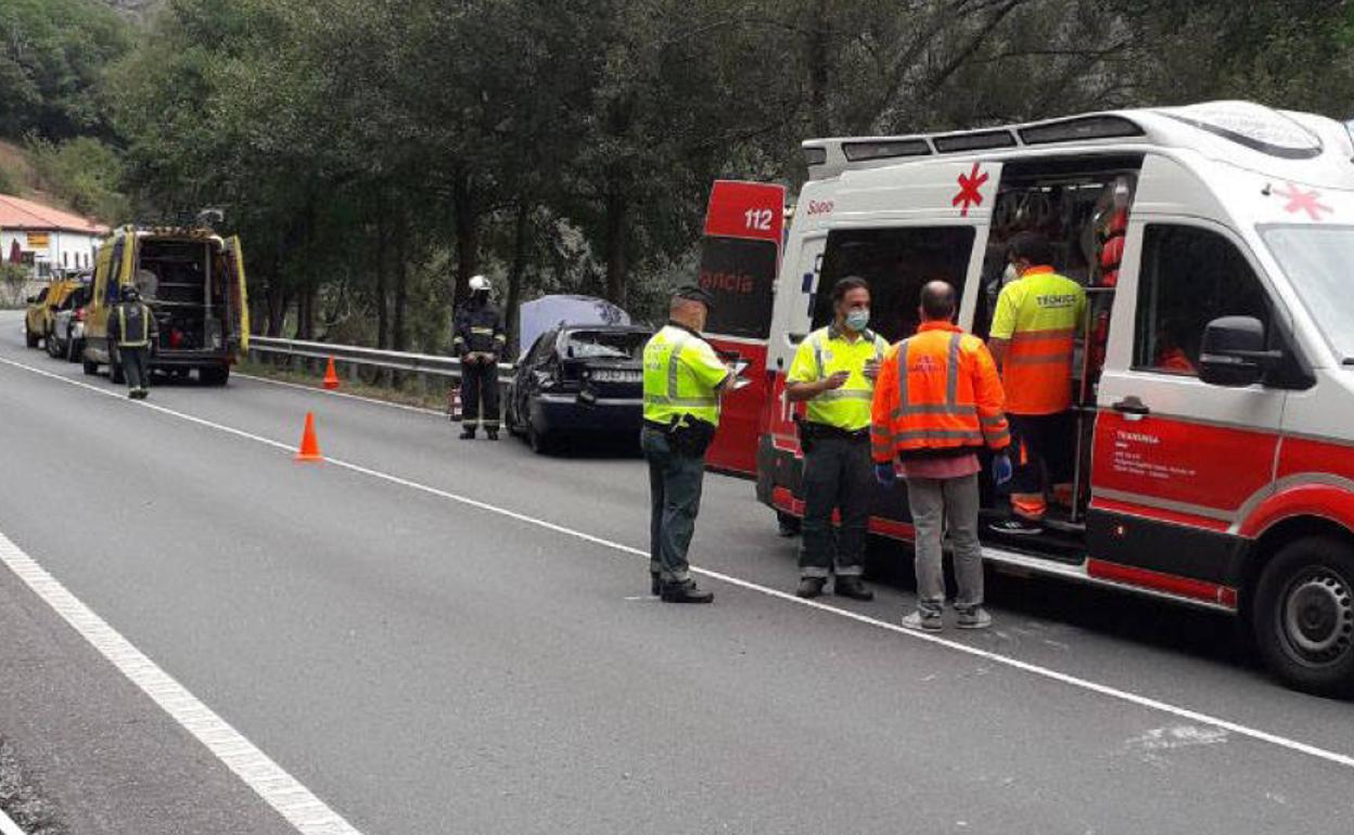 Efectivos de emergencias junto al vehículo accidentado en la AS-15.