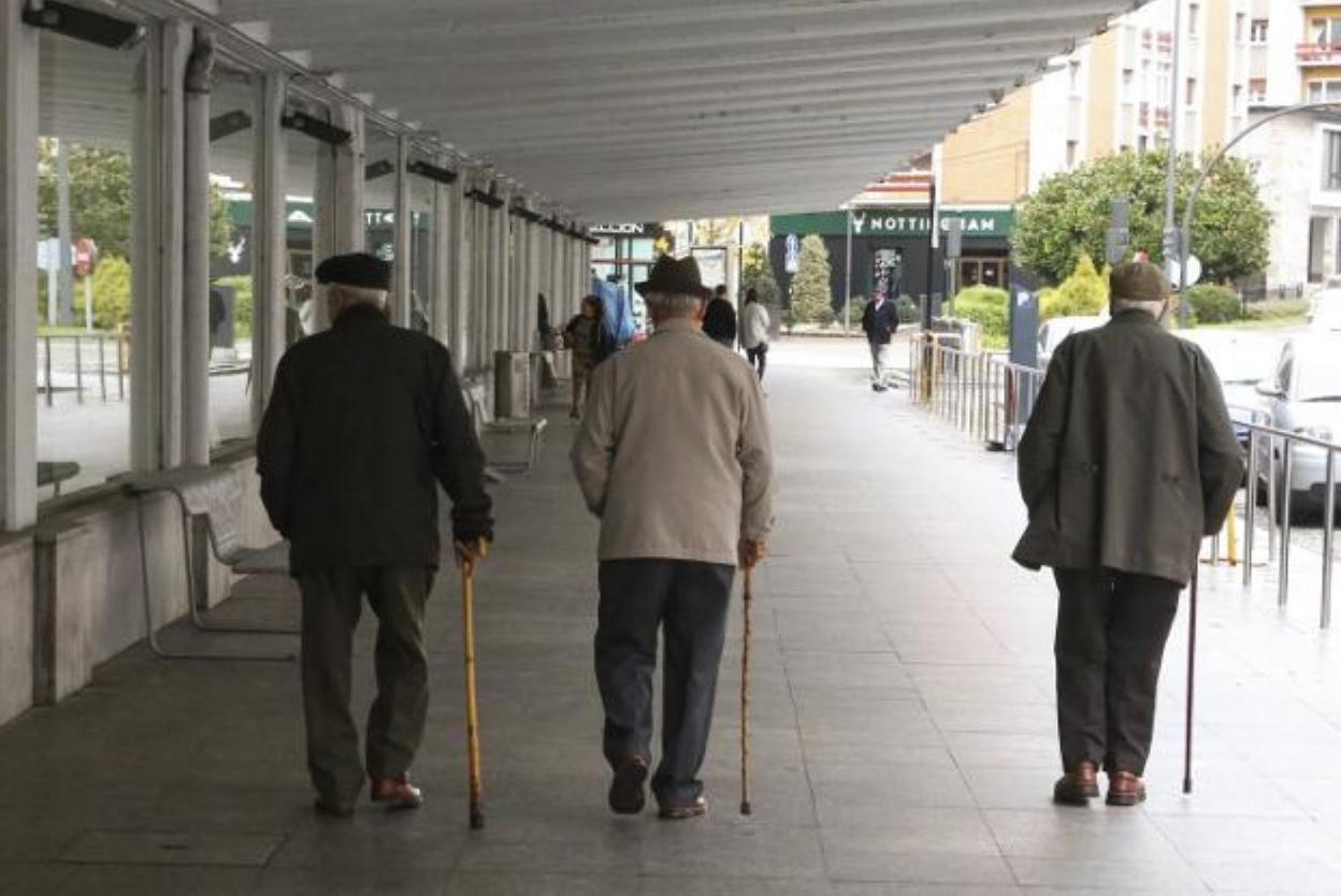 Dos personas mayores paseando por Pola de Siero. 